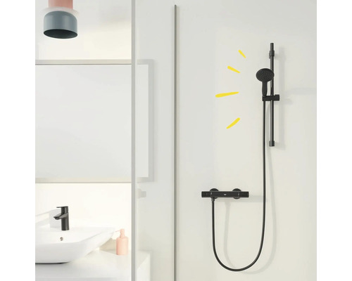 Sprchová armatúra s tyčou pre sprchovú hlavicu namontovanou na stene v kúpeľni.