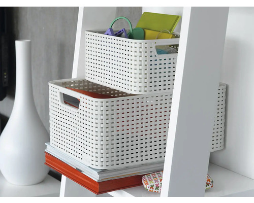 Dva biele plastové úložné koše v polici s dekoratívnymi predmetmi.