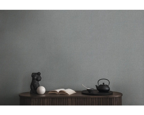 Obývacia izba so sivou textilnou tapetou, komodou, knihou a čajovým servisom