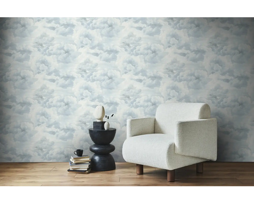 Svetlá miestnosť s tapetou s motívom oblakov, kreslom a príručným stolíkom.