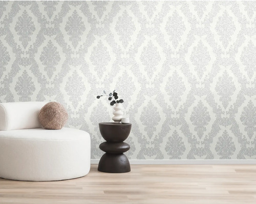 Stena s tapetami so vzorom, kreslo a príručný stolík