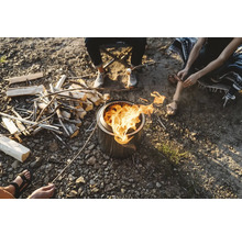 Ľudia sedia okolo ohniska a opekajú si marshmallows