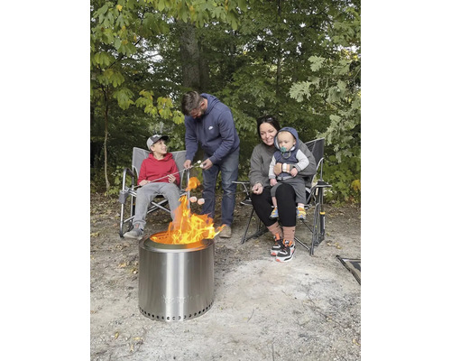 Rodina opeká marshmallows nad vonkajším ohniskom.