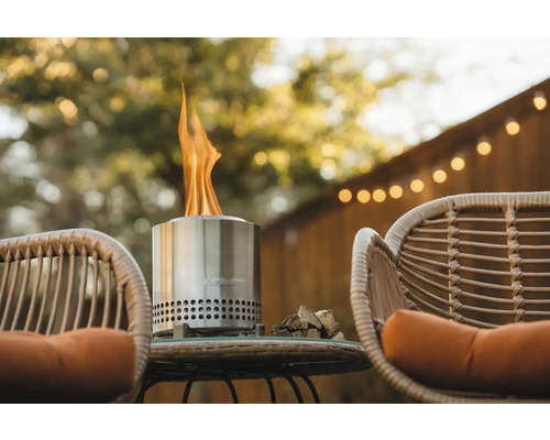 Vonkajšia scéna s ohniskom z nehrdzavejúcej ocele na stole medzi dvoma stoličkami