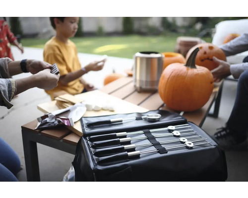 Scéna s tekvicami, nástrojmi na vyrezávanie tekvíc a ľuďmi pri stole