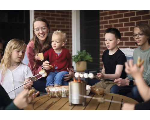 Rodina opeká marshmallows na stolnom grile vonku