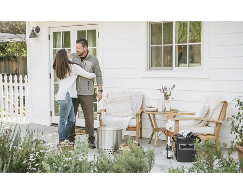 Pár sa objíma na terase s nábytkom a ohniskom