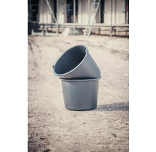 Dve plastové vedrá na maltu naskladané na seba na stavenisku.