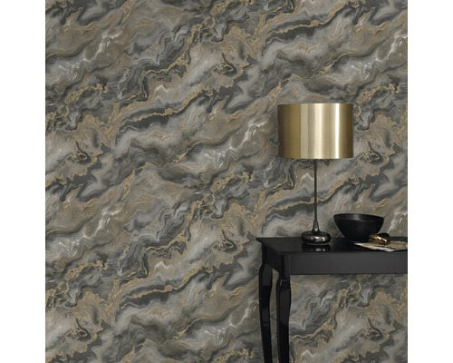 Detail steny s mramorovou tapetou v sivých a zlatých tónoch, zdobenej lampou a dekoratívnymi predmetmi na stole
