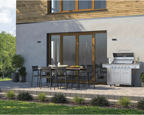 Terasa s grilom, záhradným stolom a stoličkami pred fasádou domu