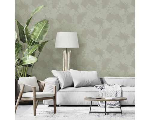 Obývacia izba s rastlinnou tapetou, pohovkou, kreslom, stolom a stojacou lampou pre svetlú a usporiadanú atmosféru.