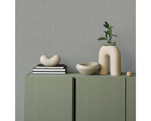 Pohľad do miestnosti s geometrickou tapetou, zelenou skriňou a dekoratívnymi predmetmi