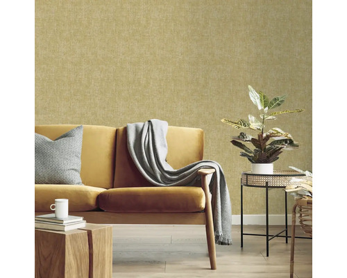 Obývacia izba so žltou pohovkou, stolom a izbovou rastlinou pred vzorovanou tapetou