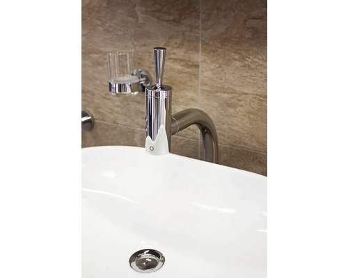 Snímka umývadla s kovovou batériou a dávkovačom mydla na stene