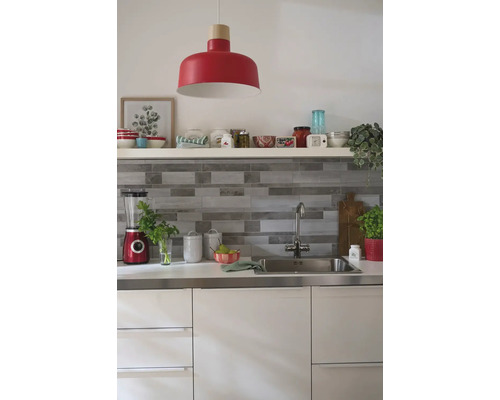 Svetlá kuchyňa s drezom, batériou, kuchynskými spotrebičmi a červenou závesnou lampou.