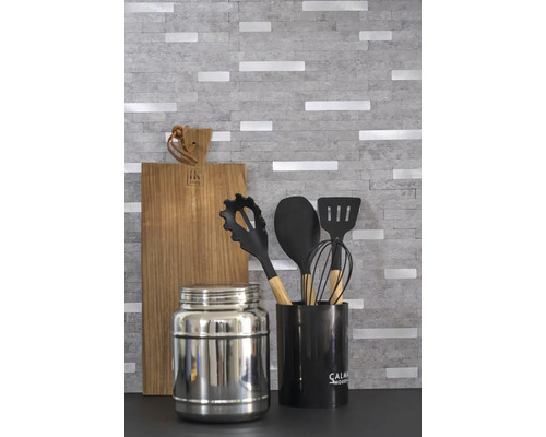 Kuchynská scéna s doskou na krájanie, kuchynským náradím a dózou na potraviny.