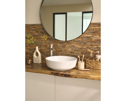 Kúpeľňa s okrúhlym zrkadlom, umývadlom na dosku, vodovodnou batériou a dekoráciou na drevenej doske