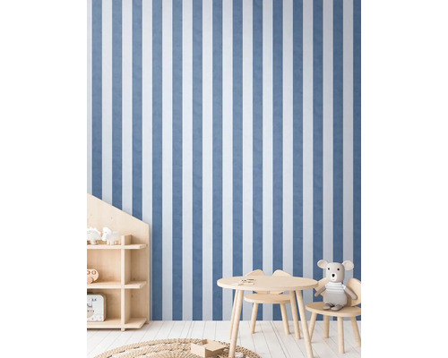 Detská izba s pruhovanou tapetou, detským stolom a regálom.