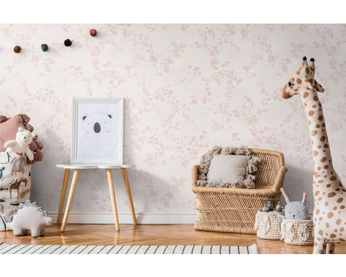 Detská izba s tapetou s kvetinovým vzorom, ratanovým nábytkom a plyšovými zvieratkami.