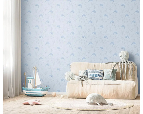 Zdobená detská izba s tapetou so vzorom delfínov, pohovkou, hračkami a drevenou podlahou.