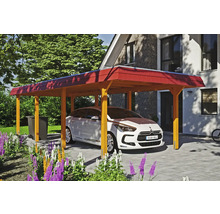 Auto stojí pod dreveným prístreškom pre auto na dláždenom dvore pred domom.