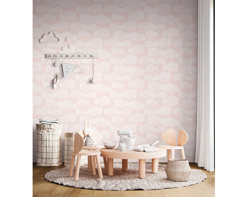 Detská izba s obláčikovou tapetou, dreveným stolom a stoličkami na okrúhlom koberci