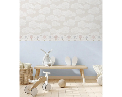 Detská izba s tapetou s motívom oblakov a teplovzdušných balónov, drevenou lavicou a hračkami