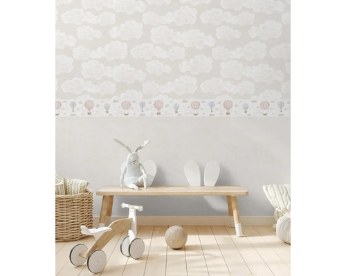 Detská izba s tapetou s oblakmi a bordúrou s teplovzdušnými balónmi, zdobená hračkami