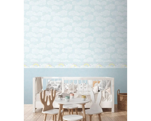 Detská izba s tapetou s motívom oblakov a detským nábytkom.