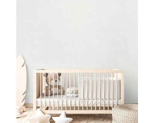 Detská izba s detskou postieľkou, plyšovým medvedíkom a dekoráciami.