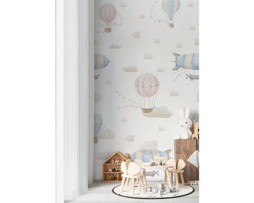 Detská izba s tapetou zobrazujúcou teplovzdušné balóny a oblaky, s detským nábytkom