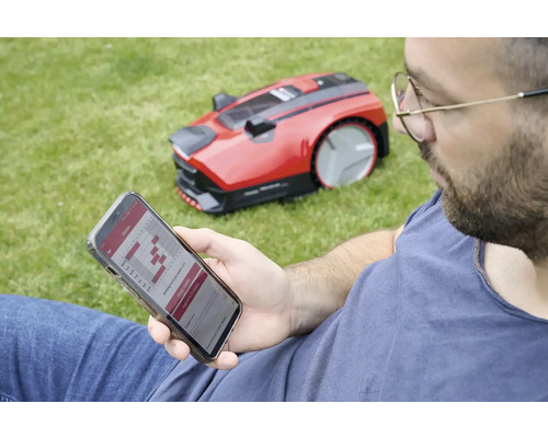 Muž programuje robotickú kosačku cez smartfón