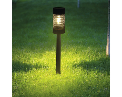 Dekoratívna záhradná lampa z kovu na trávniku.