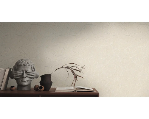 Obývacia izba s tapetou so vzorom, hromadou kníh a dekoratívnymi predmetmi na príborníku