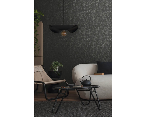 Obývacia izba s pohovkou, kreslom, stolom, závesnou lampou a vzorovanou tapetou.