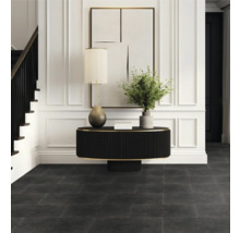 Vstupný priestor s tmavou podlahou, stolom, lampou a schodiskom