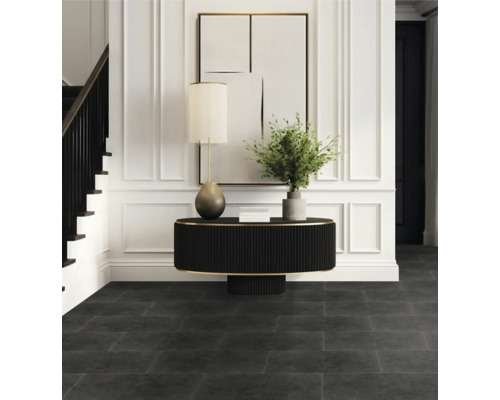 Vstupný priestor s tmavou podlahou, stolom, lampou a schodiskom