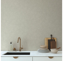 Kuchynský drez s batériou a riadom pred svetlou stenou