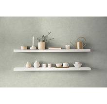 Dve biele police na stene zdobené vázami, sviečkou, kanvou a riadom