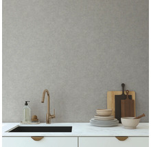 Kuchynská scéna s umývadlom, batériou, riadom a doskami na krájanie pred svetlosivou stenou