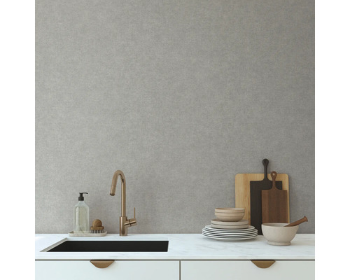 Kuchynská scéna s umývadlom, batériou, riadom a doskami na krájanie pred svetlosivou stenou