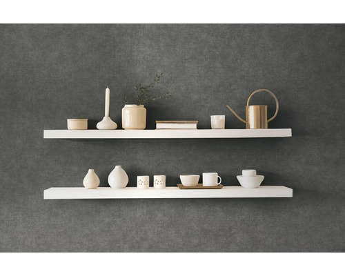 Dve biele nástenné police s dekoratívnymi predmetmi na tmavej stene