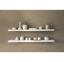 Dve biele police s dekoratívnymi predmetmi na stene