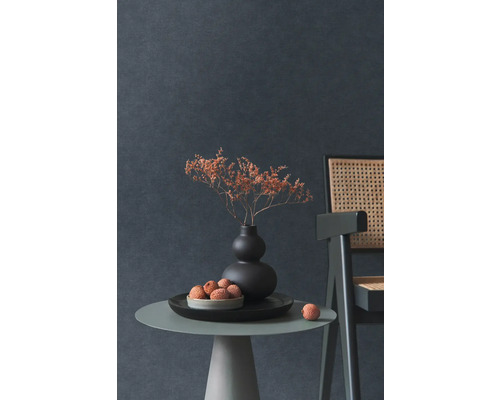 Dekoratívne zátišie so sušenými kvetmi vo váze, miskou s ovocím a stoličkou na odkladacom stolíku pred tmavou stenou