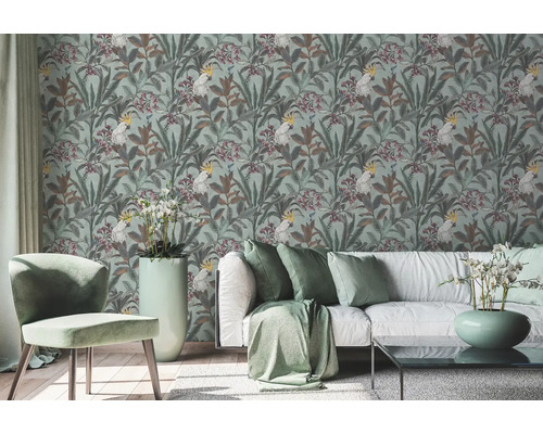 Obývacia izba s tapetou so vzorom kakadu a rastlinnými motívmi, pohovka a stolička.