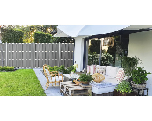 Záhradné posedenie s plotom na ochranu súkromia a slnečníkom