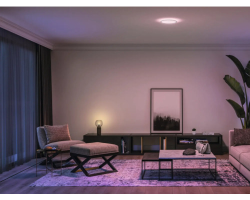 Moderná obývacia izba so stropným svietidlom, sedacím nábytkom a dekoráciami.