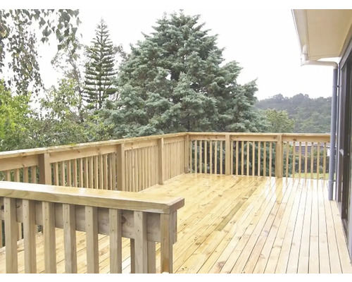 Drevená terasa so zábradlím a výhľadom do zelene