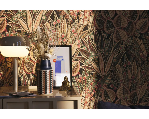 Dekoratívna izba s vzorovanou tapetou, lampou, vázou so sušenými kvetmi a figúrkou Budhu