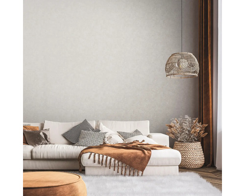 Obývacia izba s pohovkou, vankúšmi, dekou, lampou a dekoráciou v útulnom dizajne.